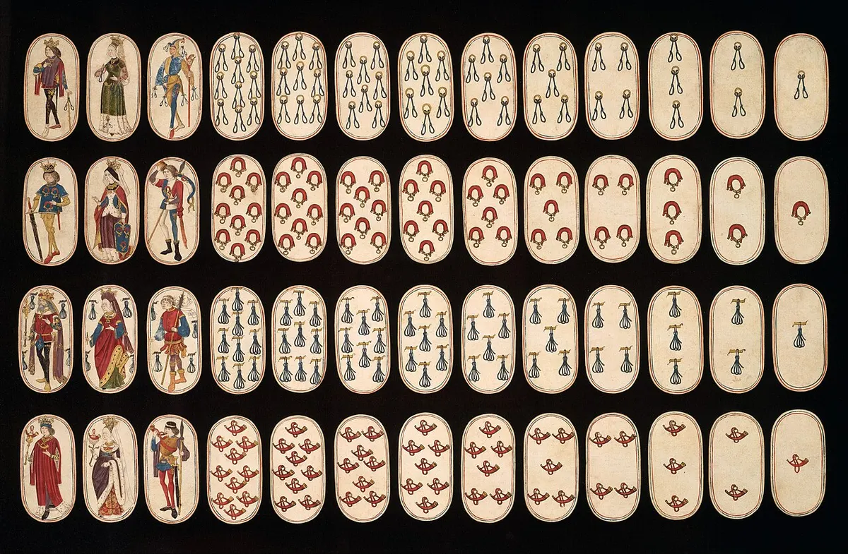 As 52 cartas do baralho The Cloisters Playing Cards dispostas em quatro fileiras sobre fundo preto, com figuras de reis, damas e valetes e naipes de objetos de caça